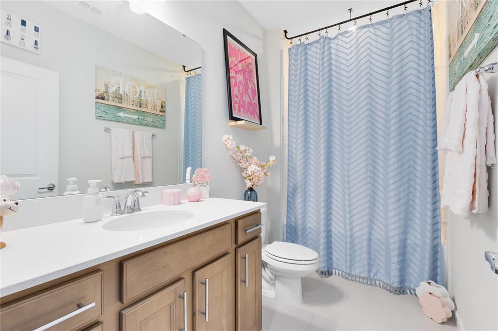 6528 Rover Way St. Cloud, FL 34771 - Photo 15 of 26 a bathroom with a sink a toilet and shower curtain