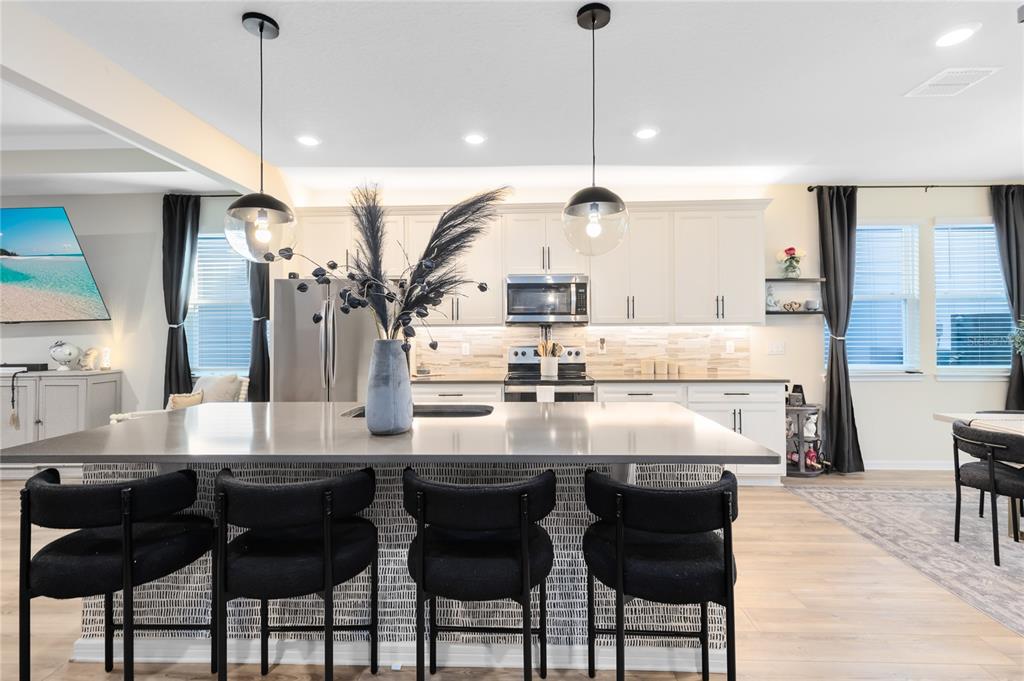 6528 Rover Way St. Cloud, FL 34771 - Photo 3 of 26 a kitchen with stainless steel appliances kitchen island granite countertop a table chairs and a kitchen view