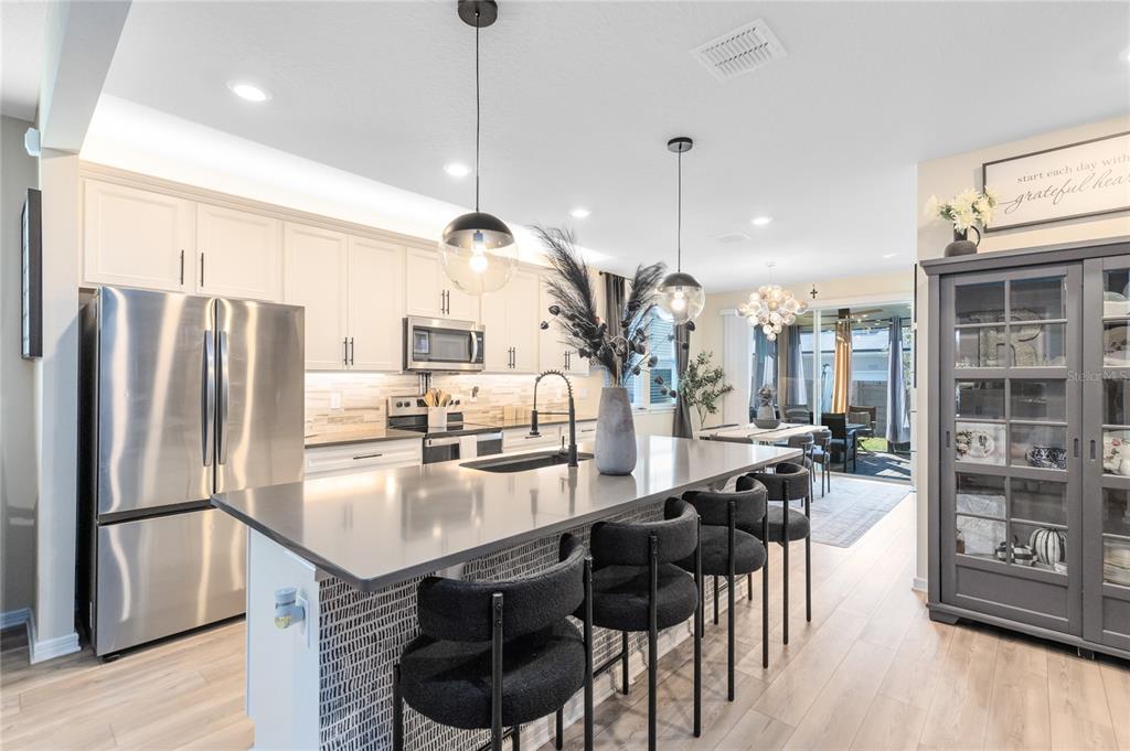 6528 Rover Way St. Cloud, FL 34771 - Photo 4 of 26 a kitchen with stainless steel appliances granite countertop a table chairs stove and refrigerator