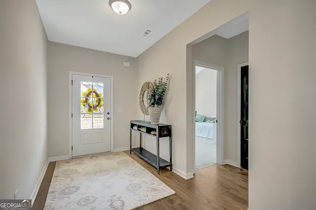 a dining room with stainless steel appliances granite countertop a dining table chairs refrigerator and microwave