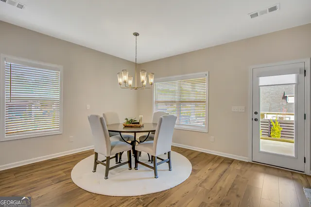 a living room with furniture kitchen view and a wooden floor