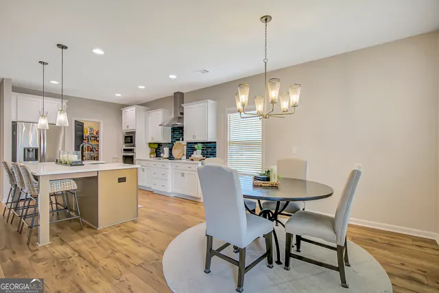 a view of a dining room with furniture a chandelier and wooden floor