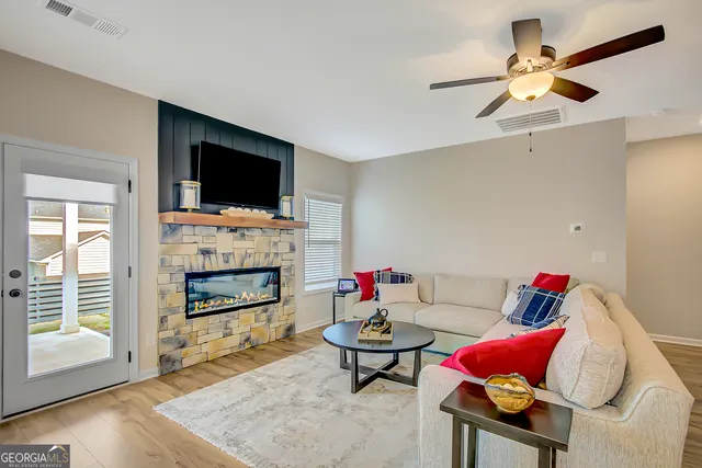 a kitchen with stainless steel appliances kitchen island granite countertop a stove a sink a microwave a dining table and chairs with wooden floor