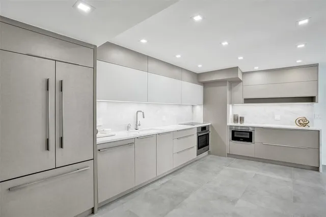 a kitchen with stainless steel appliances a refrigerator sink and white cabinets