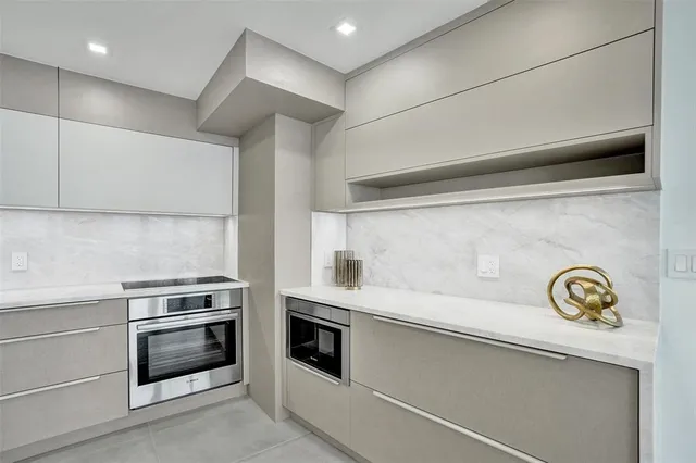 a view of a kitchen with a sink and dishwasher a refrigerator with white cabinets