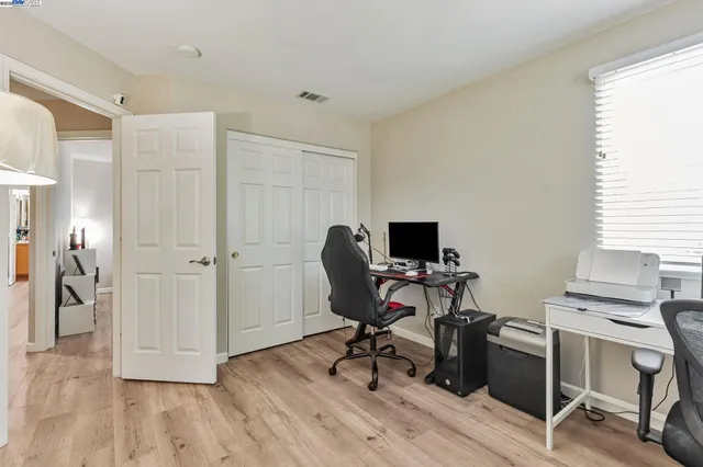 a view of a workspace with furniture and a window