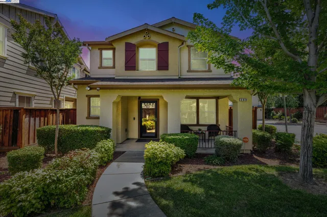 a view of a house with brick walls and a yard with plants