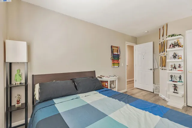 a bedroom with a bed and wooden floor