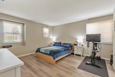 a spacious bedroom with a bed and a large window