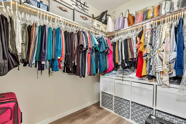 a view of walk in closet with clothes
