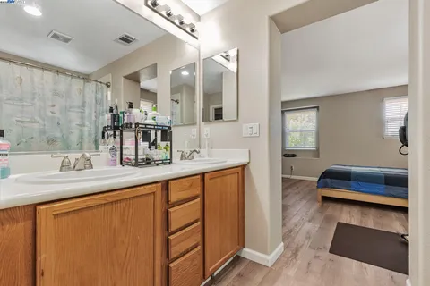 a en suite bathroom with a double vanity sink and a mirror