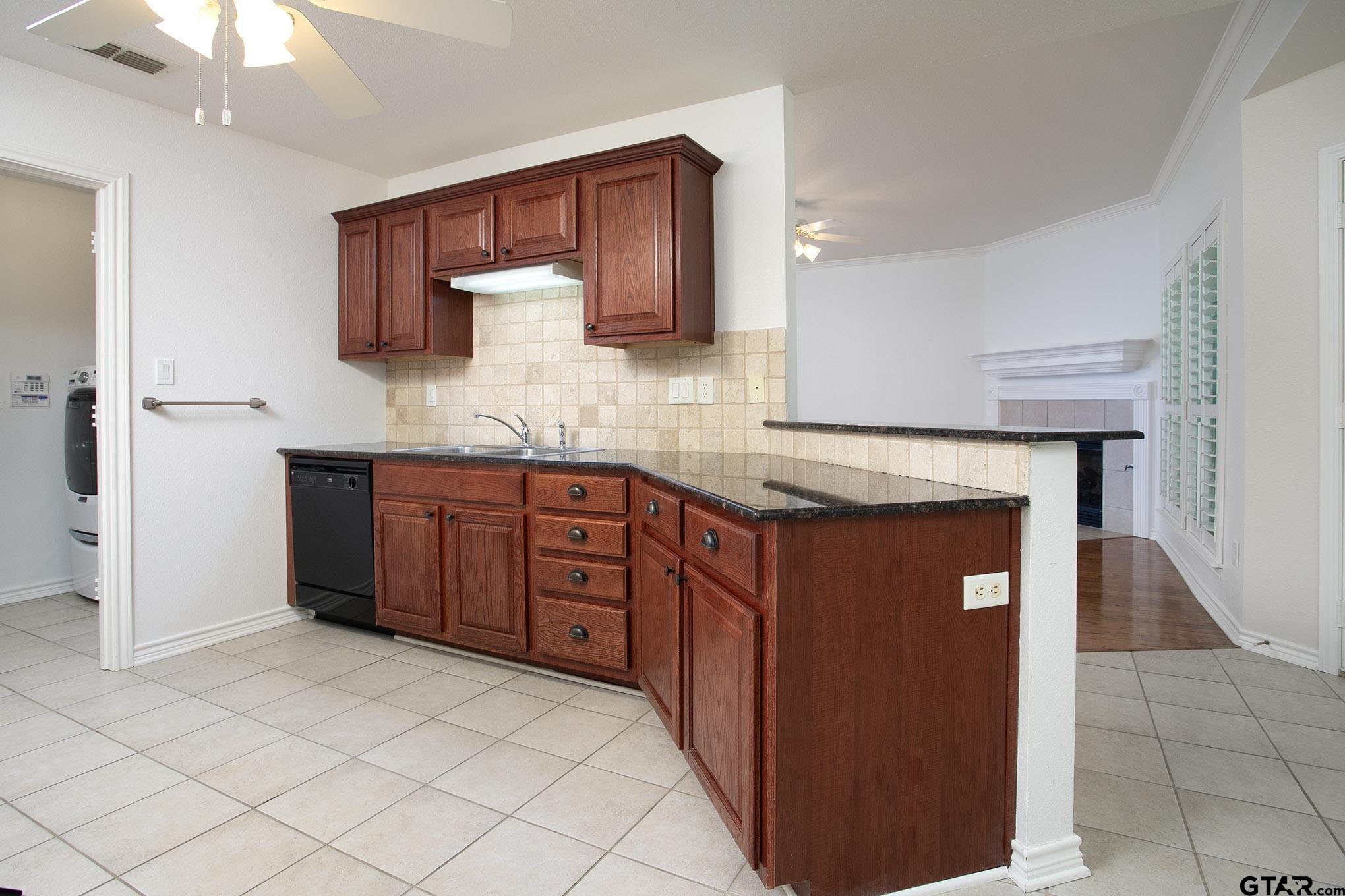 1521 Rice Road, Unit E105 Tyler, TX 75703 - Photo 13 of 32 a kitchen with stainless steel appliances granite countertop a stove and a sink