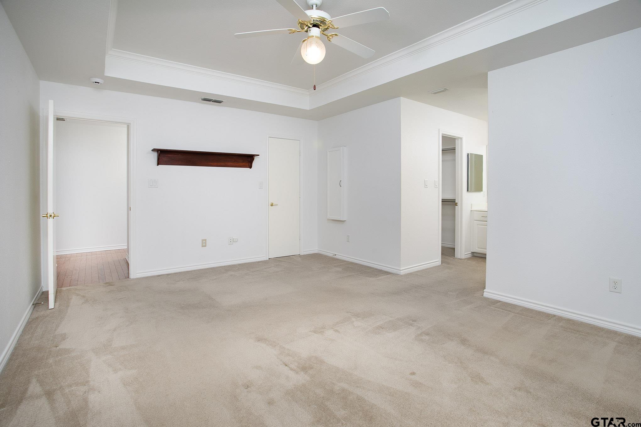 1521 Rice Road, Unit E105 Tyler, TX 75703 - Photo 18 of 32 an empty room with a ceiling fan and a window