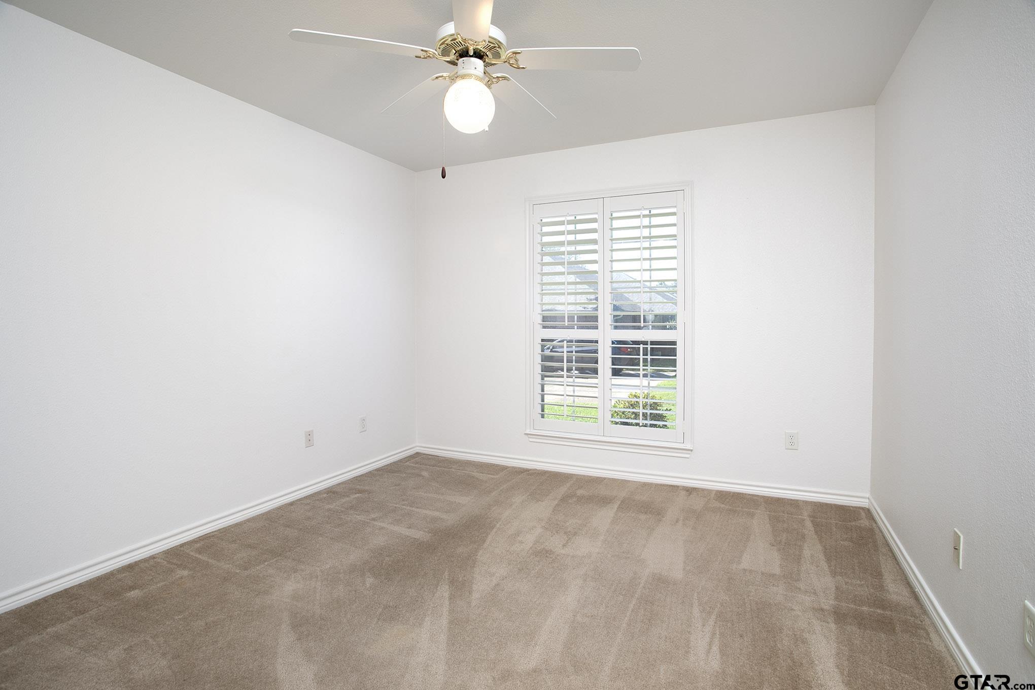 1521 Rice Road, Unit E105 Tyler, TX 75703 - Photo 23 of 32 an empty room with a window and a fan