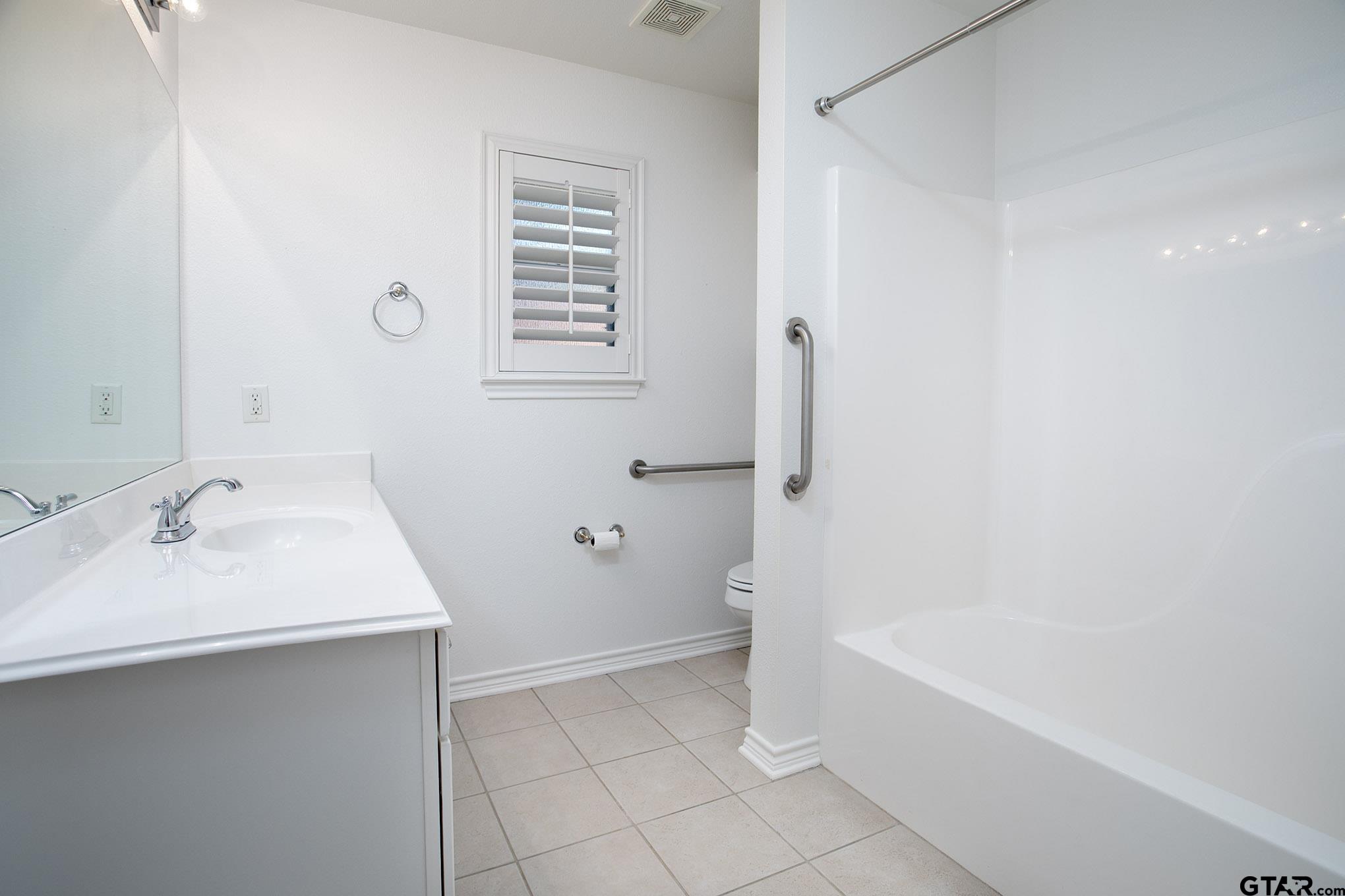 1521 Rice Road, Unit E105 Tyler, TX 75703 - Photo 25 of 32 a bathroom with a sink a bathtub and a shower