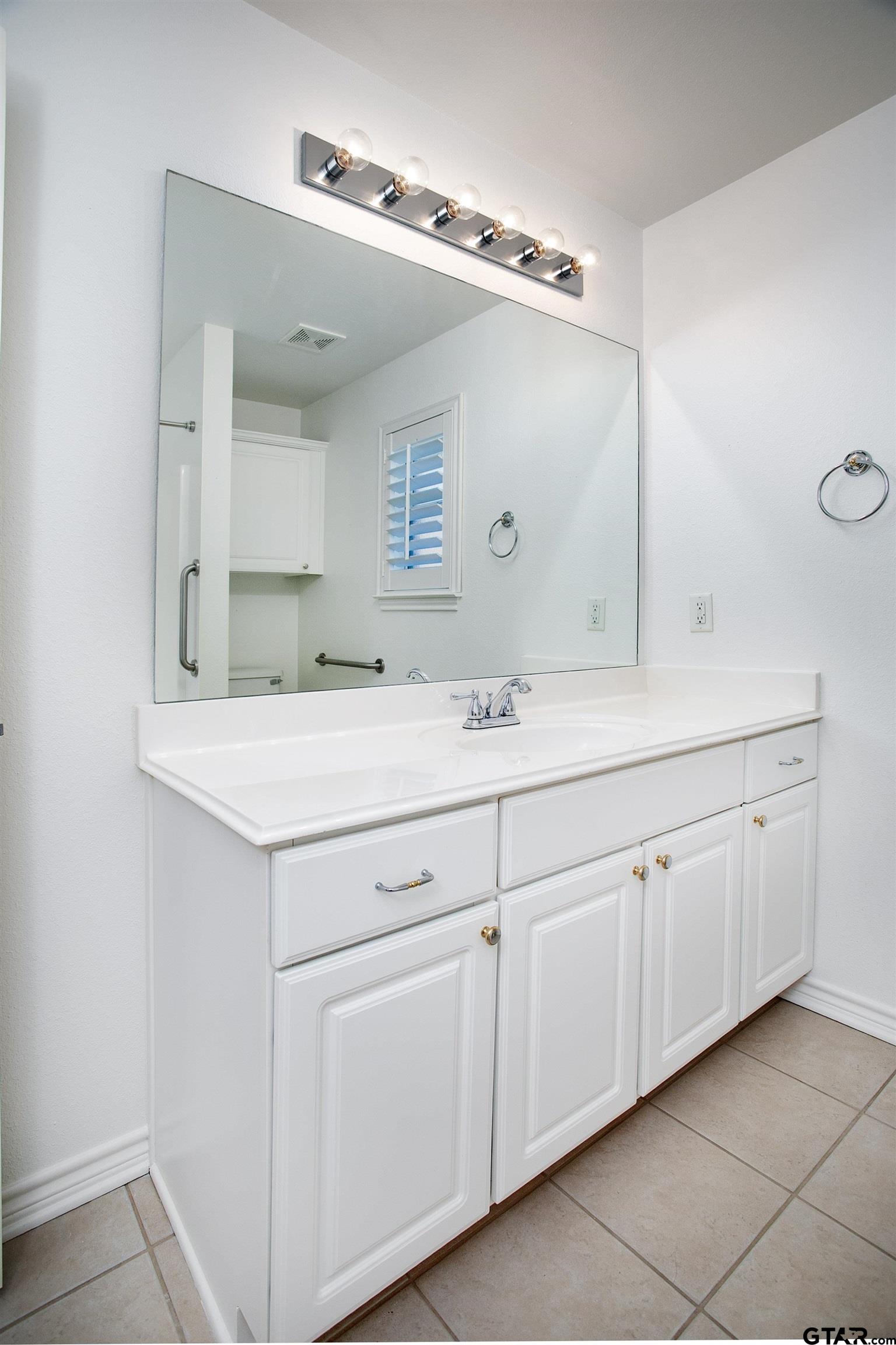 1521 Rice Road, Unit E105 Tyler, TX 75703 - Photo 26 of 32 a bathroom with a sink and a mirror