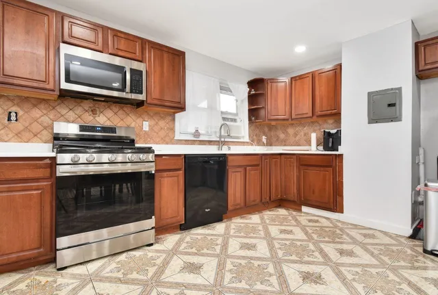 a kitchen with stainless steel appliances granite countertop a stove top oven microwave and sink
