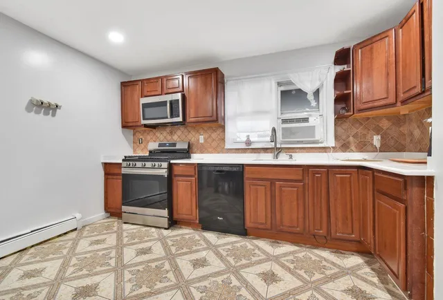 a kitchen with stainless steel appliances granite countertop a stove a sink and a microwave