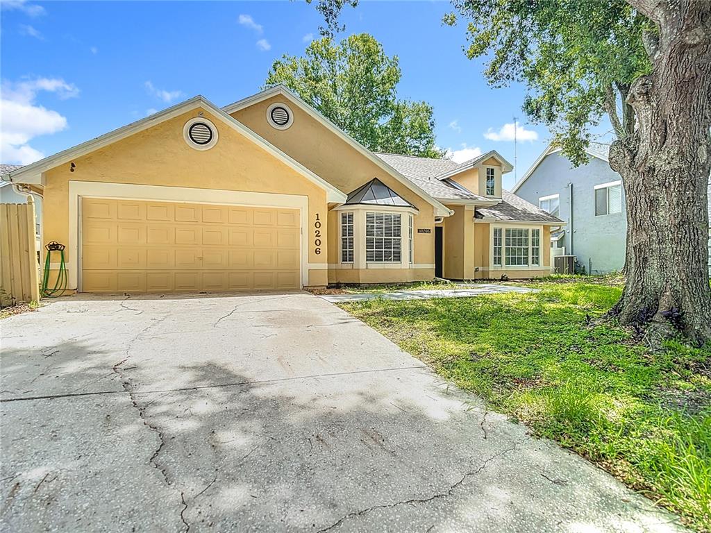 a front view of a house with a garden and trees