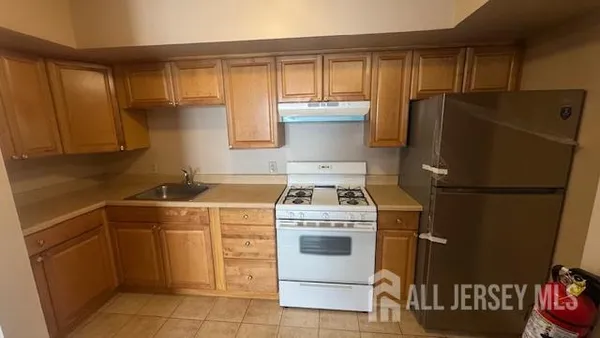a kitchen with a stove a refrigerator and a sink