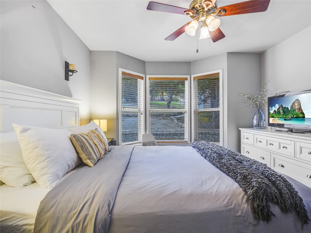 11000 Beach Road Leander, TX 78641 - Photo 13 of 38 a bedroom with a large bed and a flat tv screen