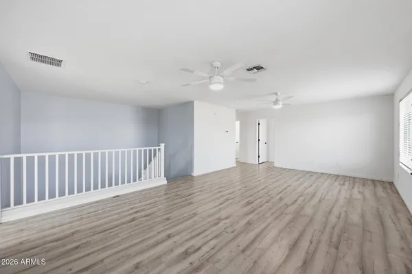 a view of an empty room with wooden floor