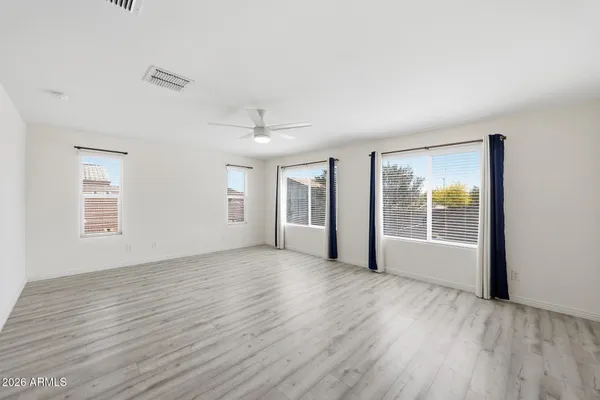 an empty room with wooden floor and windows
