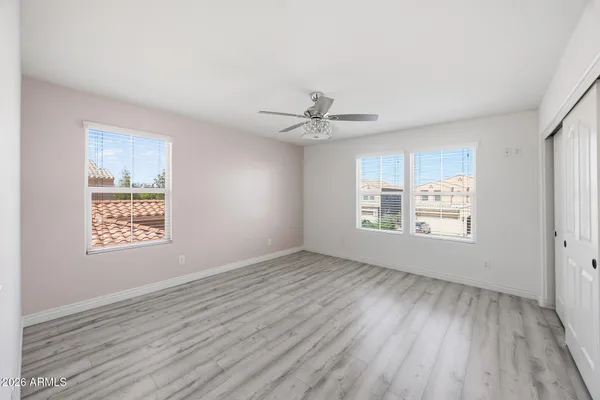a view of an empty room with a window and wooden floor