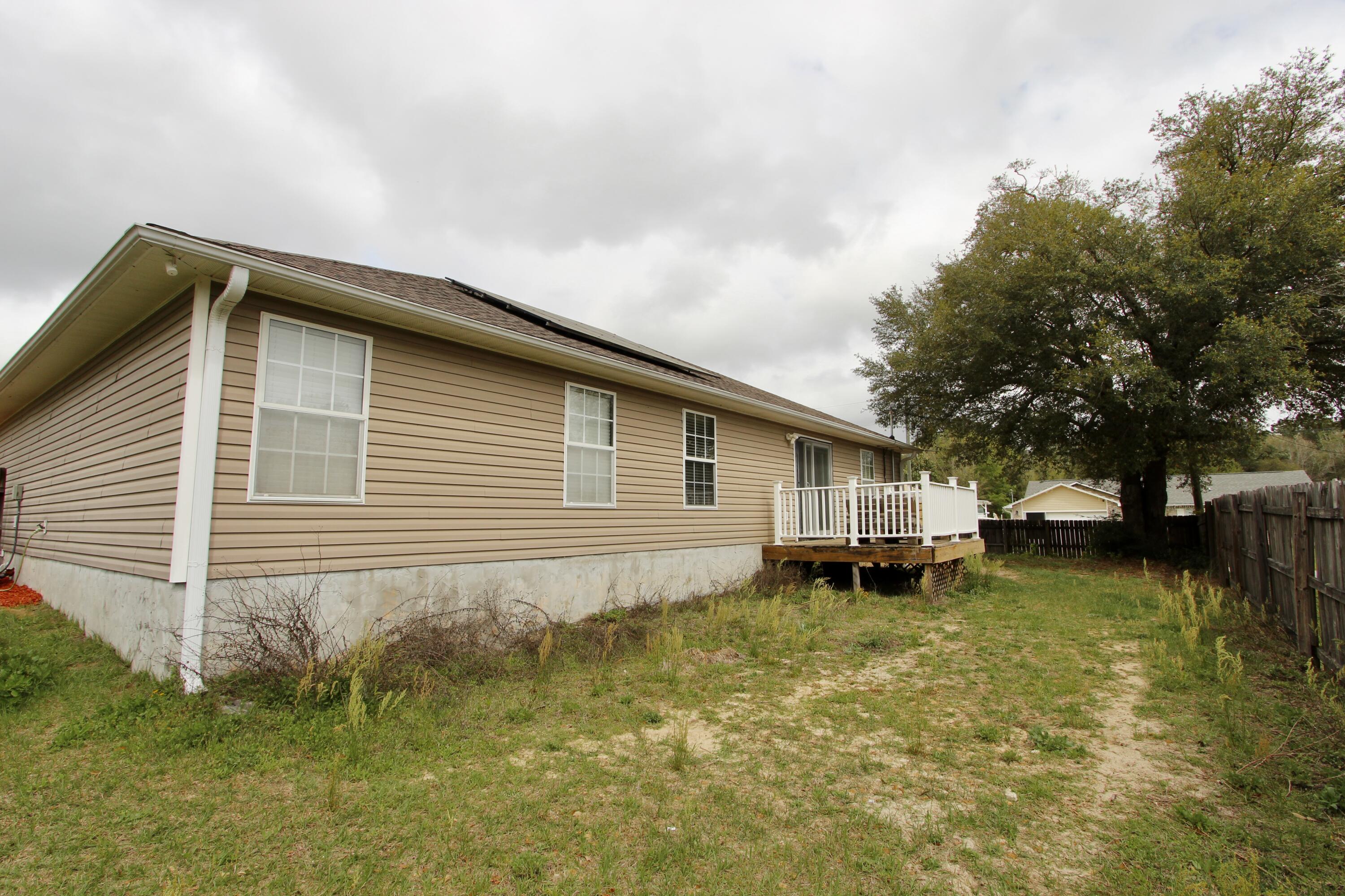 3150 Skyhawk Drive Crestview, FL 32539 - Photo 26 of 26 a backyard of a house with lots of green space and fountain