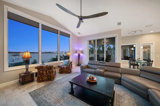 a kitchen with kitchen island granite countertop a stove top oven a sink dishwasher and white cabinets with wooden floor