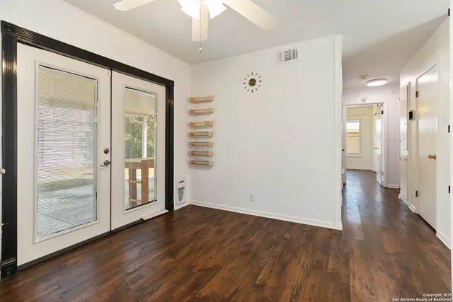 a view of a hallway with wooden floor and chandelier fan