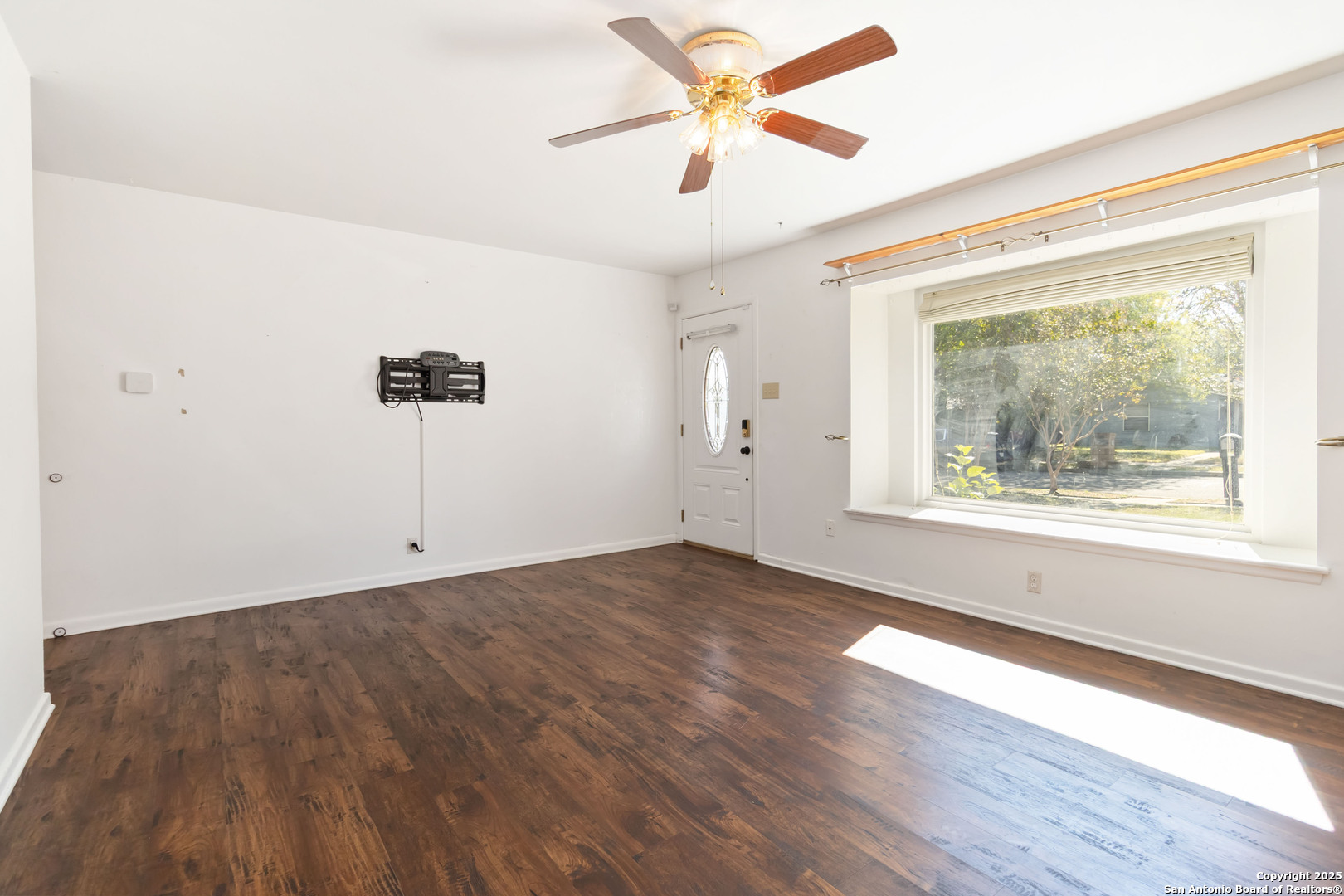 7903 Rimfire Drive San Antonio, TX 78227 - Photo 4 of 25 a view of an empty room with a window and wooden floor