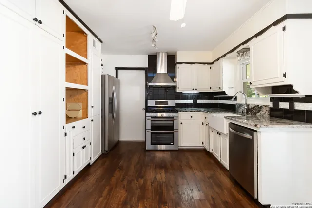 a kitchen with stainless steel appliances a refrigerator sink and cabinets