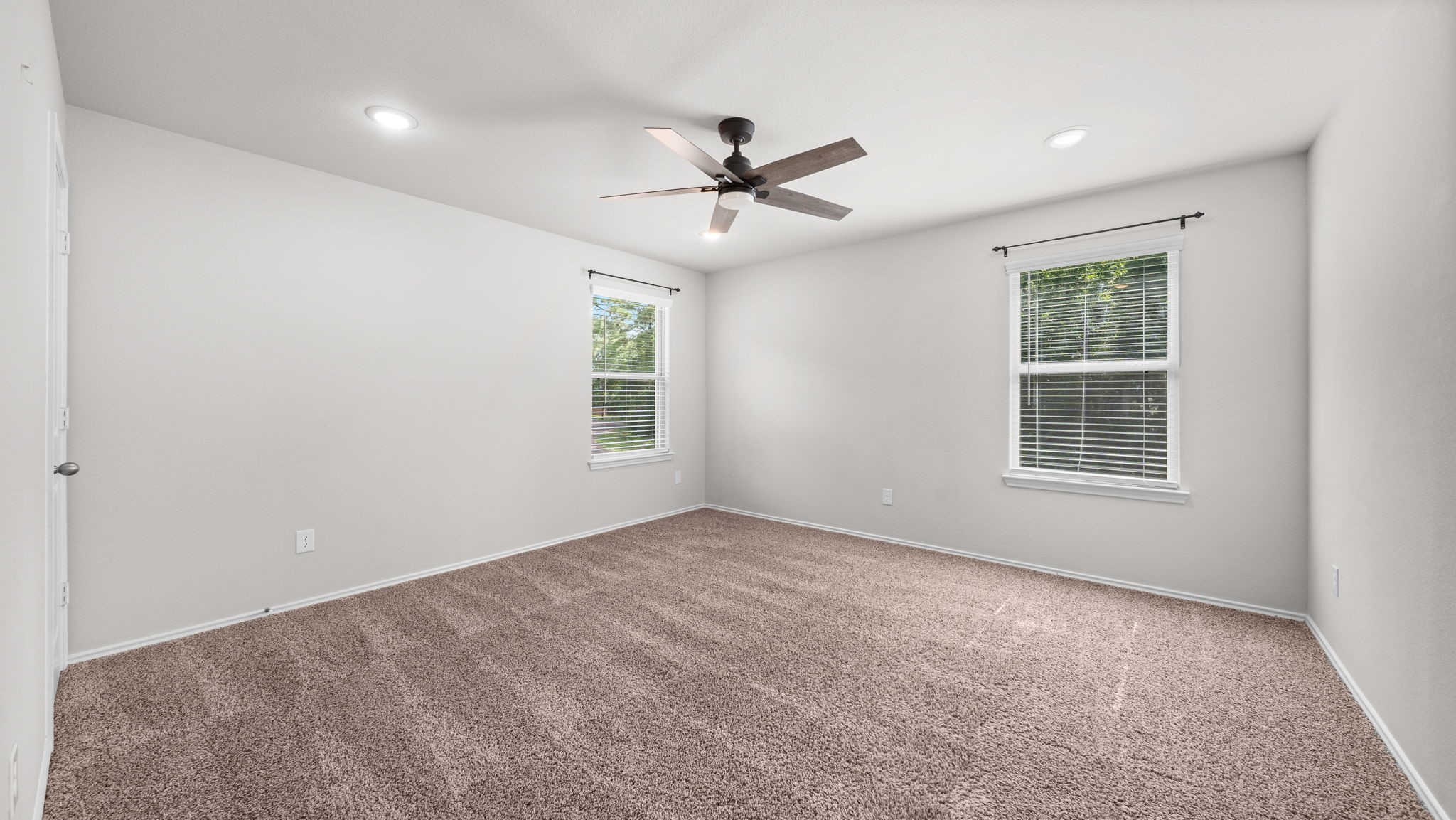 18140 Mail Rte Road Montgomery, TX 77316 - Photo 17 of 26 Secondary bedroom with plush carpeting, ceiling fan, and abundant natural light.