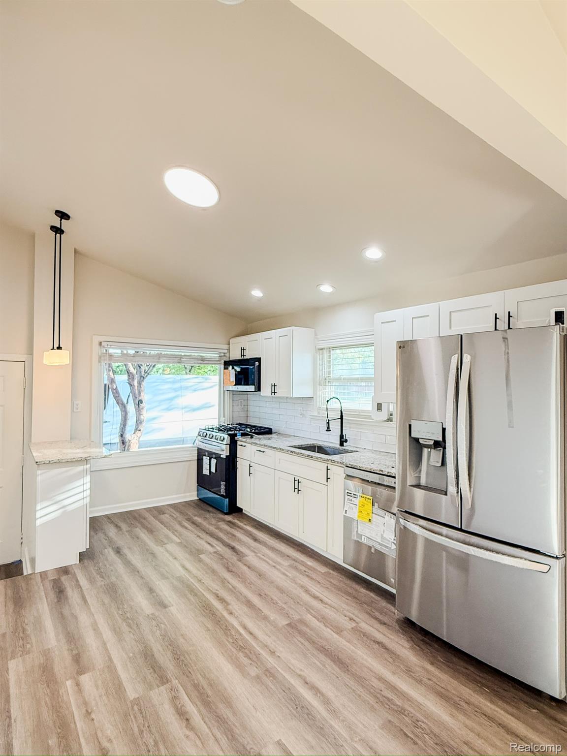 30052 Schoenherr Road Warren, MI 48088 - Photo 12 of 38 Modern kitchen featuring white cabinetry, stone countertops, and stainless steel appliances