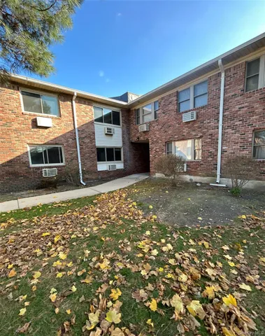 a front view of a house with a large tree