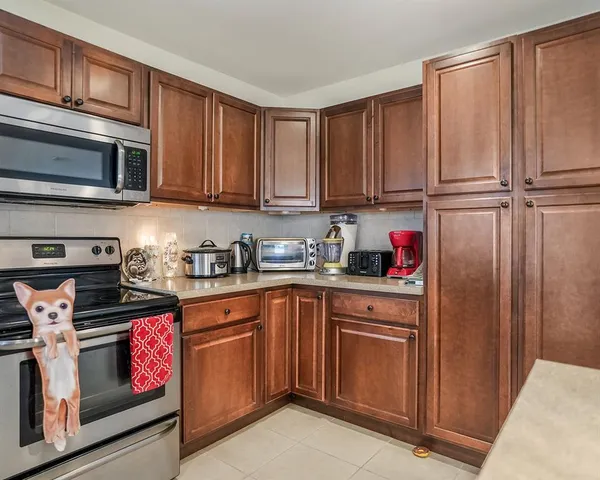a kitchen with granite countertop stainless steel appliances wooden cabinets and a sink