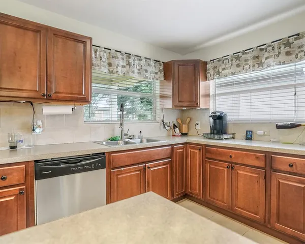 a kitchen with granite countertop sink stainless steel appliances and cabinets