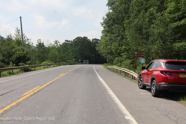 a view of a city street with a car parked on the road