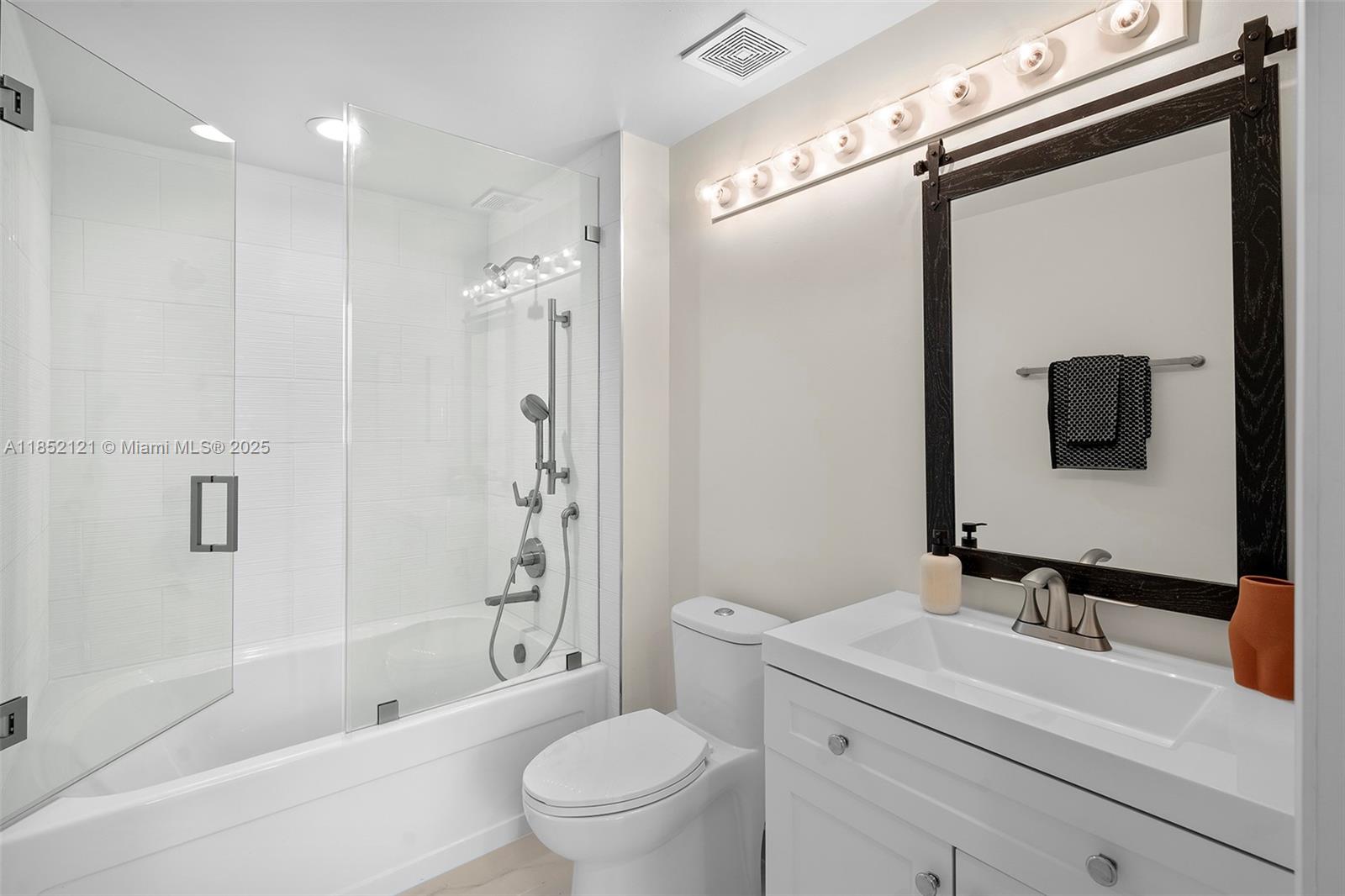 1155 Brickell Bay Drive, Unit 203 Miami, FL 33131 - Photo 17 of 36 a bathroom with a sink a toilet a mirror and shower