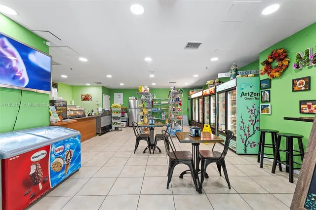 a dining hall with furniture and a kitchen