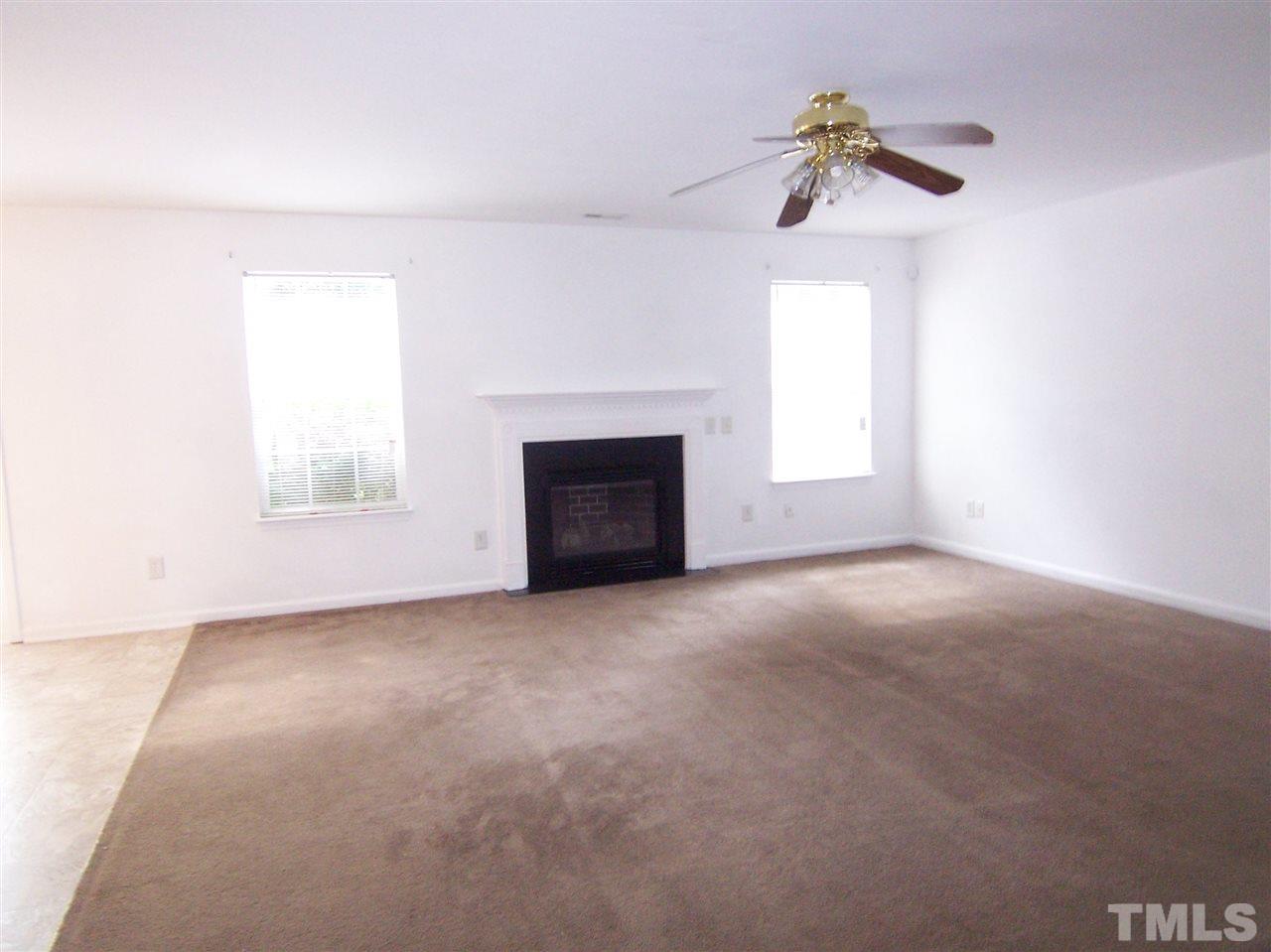3904 Tyler Bluff Lane Raleigh, NC 27616 - Photo 3 of 13 an empty room with a window and fireplace