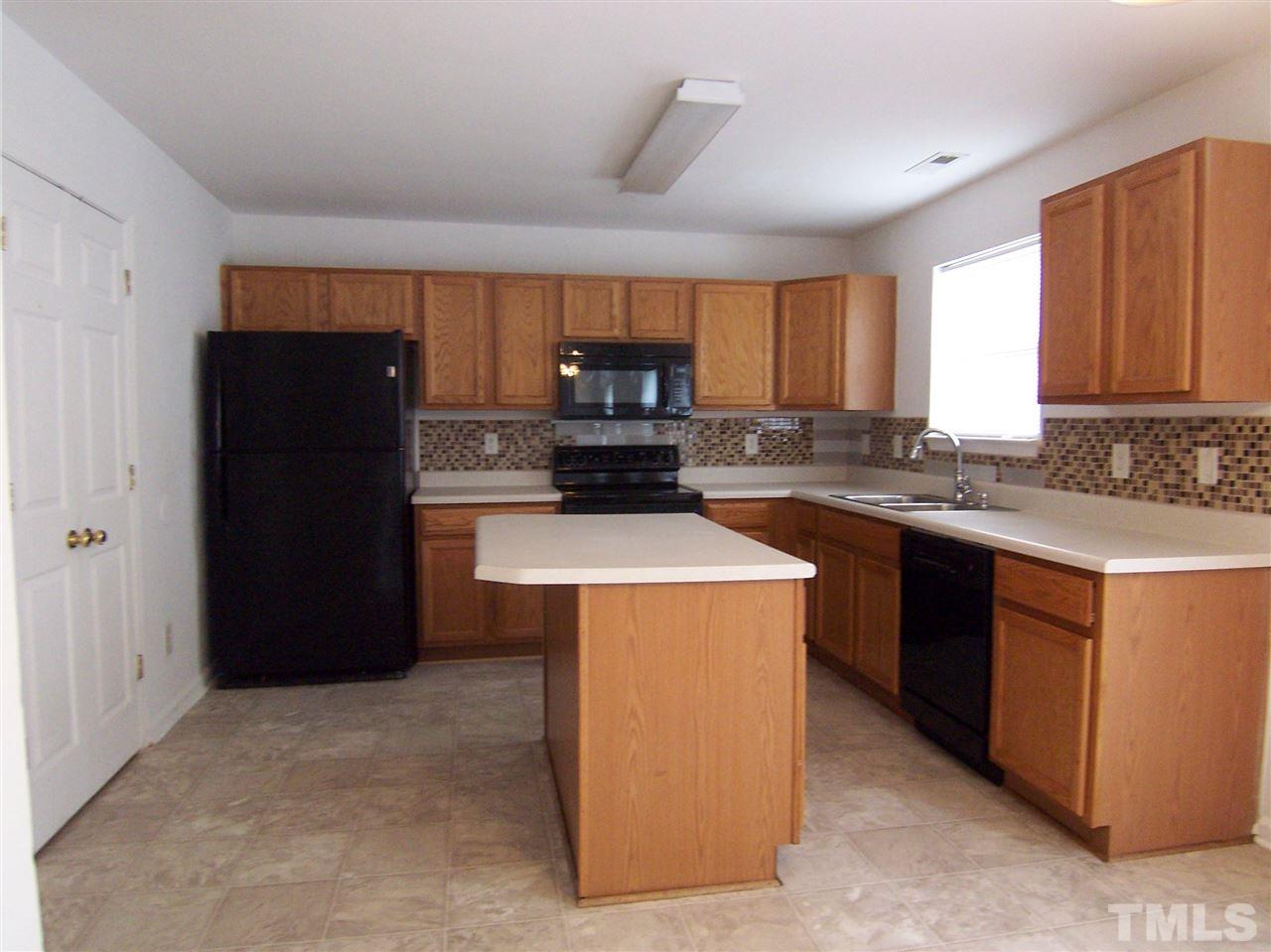 3904 Tyler Bluff Lane Raleigh, NC 27616 - Photo 4 of 13 a kitchen with a sink a stove and a refrigerator