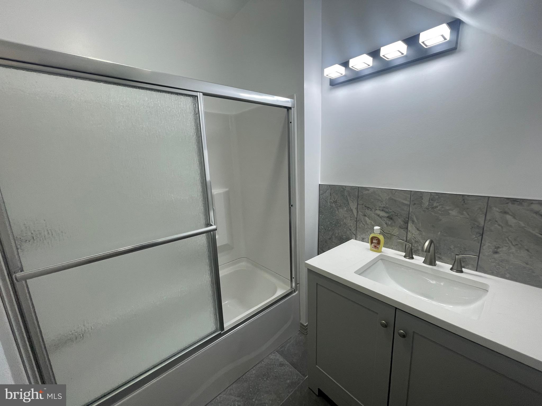 20 Pennsylvania Avenue, Unit 1 Reading, PA 19605 - Photo 15 of 17 a bathroom with a sink mirror and a shower