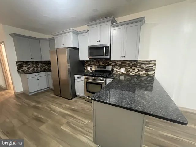 a kitchen with stainless steel appliances granite countertop a refrigerator a stove a sink and a granite counter tops