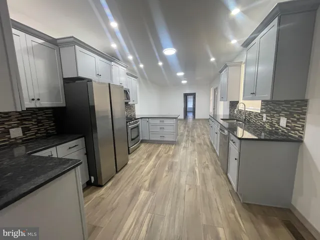 a kitchen with stainless steel appliances granite countertop a refrigerator and a stove