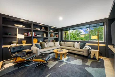 a living room with furniture a rug and a large window