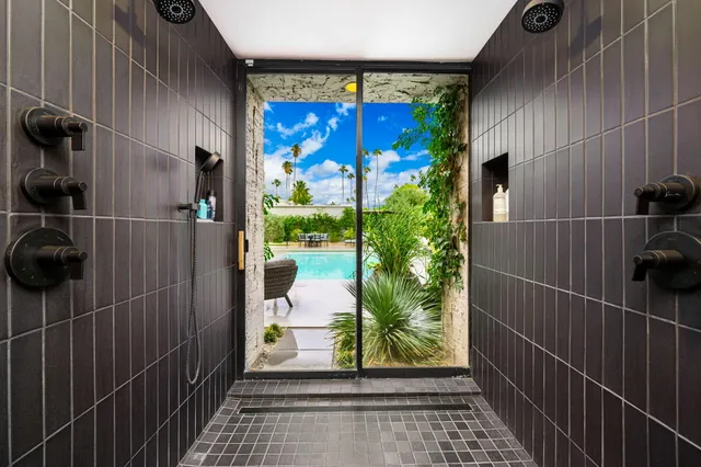 a bathroom with a sink a stove a painting on the wall and a shower