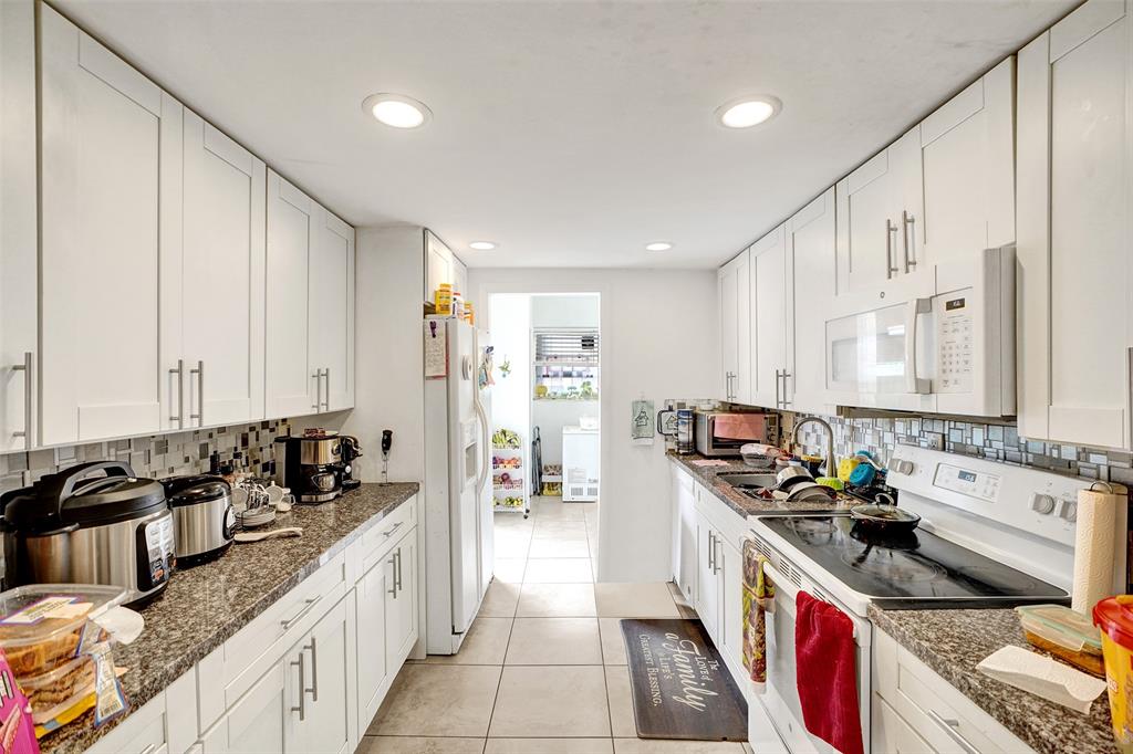 1732 West 72nd Street, Unit 1732 Hialeah, FL 33014 - Photo 11 of 58 a kitchen with stainless steel appliances granite countertop a stove a sink and a refrigerator