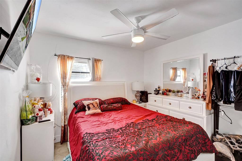 1732 West 72nd Street, Unit 1732 Hialeah, FL 33014 - Photo 21 of 58 a bedroom with a bed and a flat tv screen on the dresser